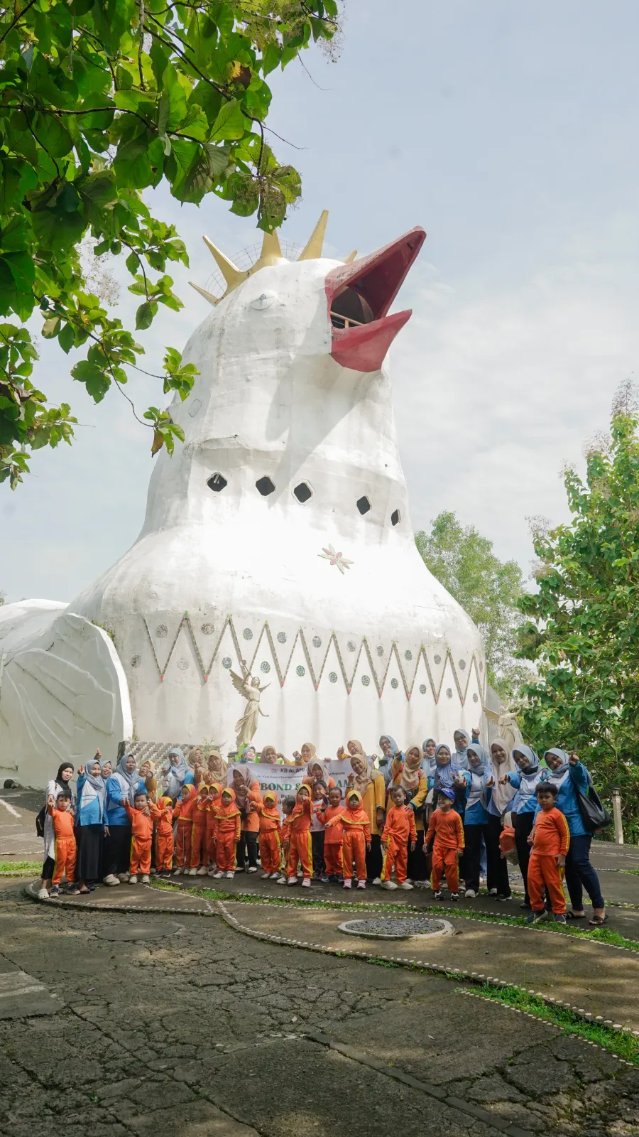 Rombongan siswa TK dan guru berfoto bersama di depan Bukit Rhema.